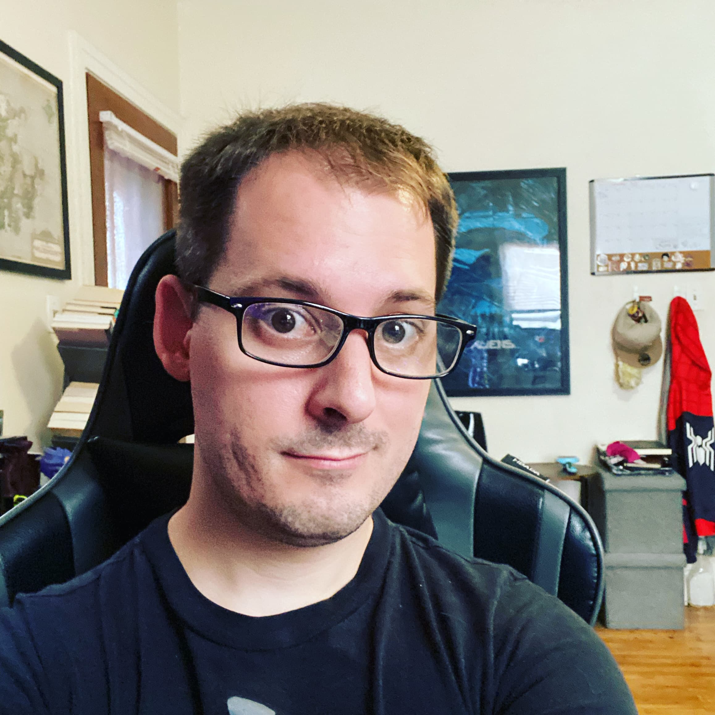 Man wearing glasses in slight profile at computer desk